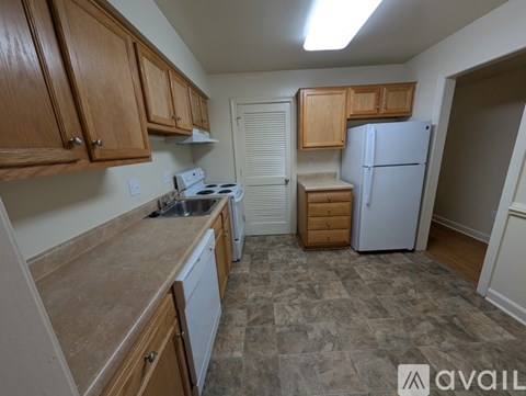 A kitchen with wooden cabinets and a white refrigerator.