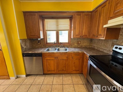 A kitchen with wooden cabinets and a black stove top oven.