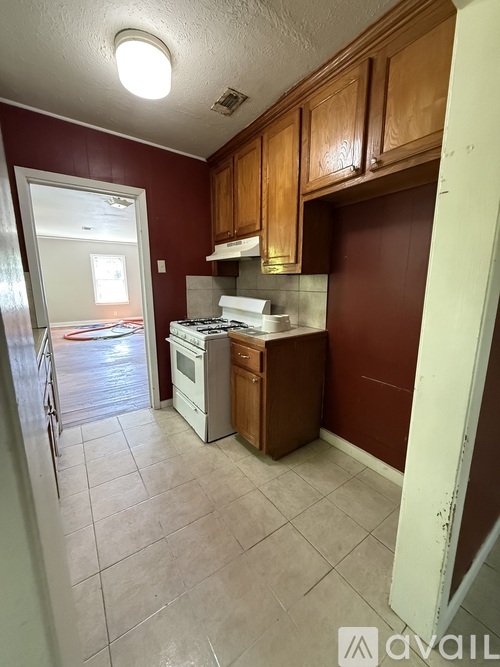 A kitchen with brown cabinets and a white stove top oven.