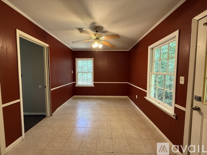 A room with a ceiling fan and a window.