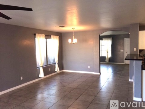 A spacious living room with a ceiling fan and tiled flooring.