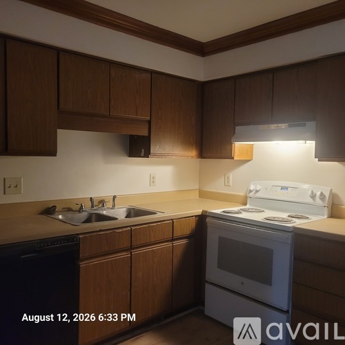 A kitchen with wooden cabinets and a white stove top oven.