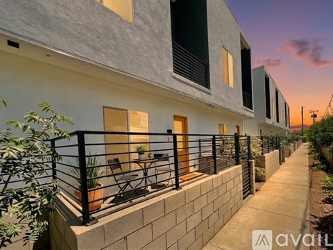 A modern house with a balcony and a patio table.