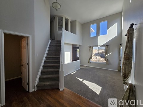 A spacious room with a staircase leading to the upper floor.