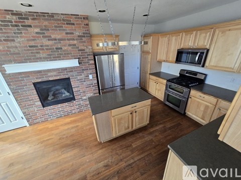 A kitchen with wooden cabinets and a brick wall.
