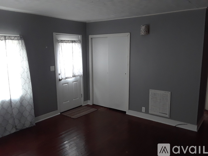 A room with a door, window, and a wall hanging.