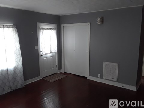 A room with a door, window, and a wall hanging.