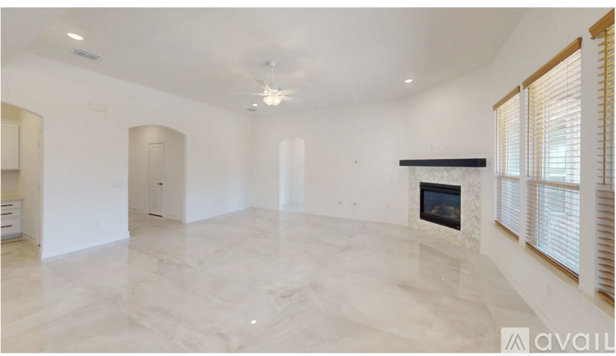 A spacious living room with a fireplace and a marble floor.