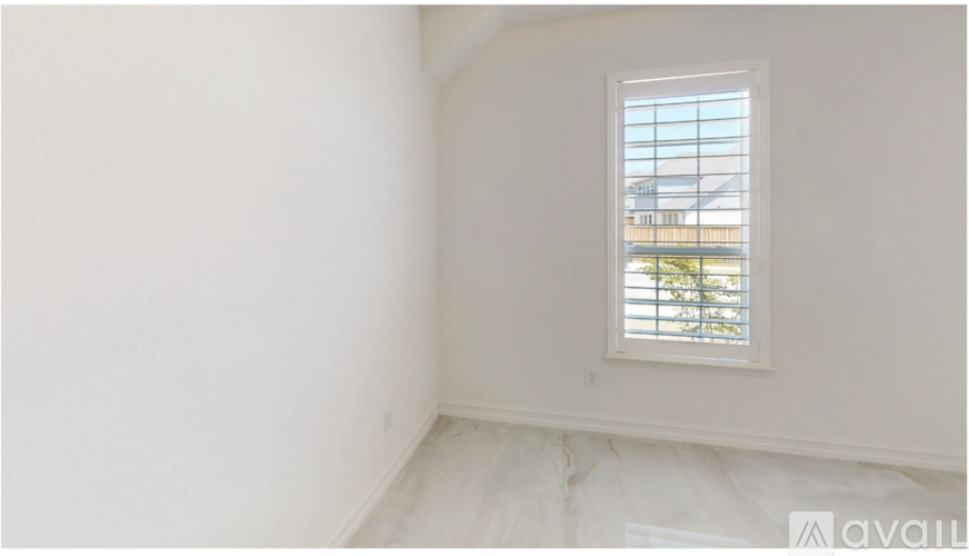 A room with a window and a view of a building outside.