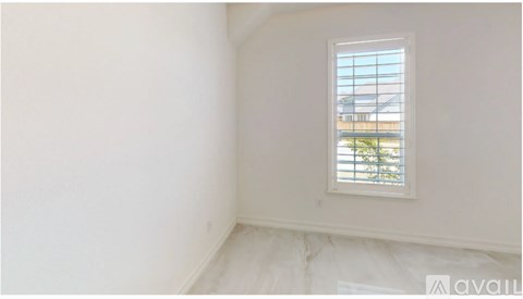 A room with a window and a view of a building outside.