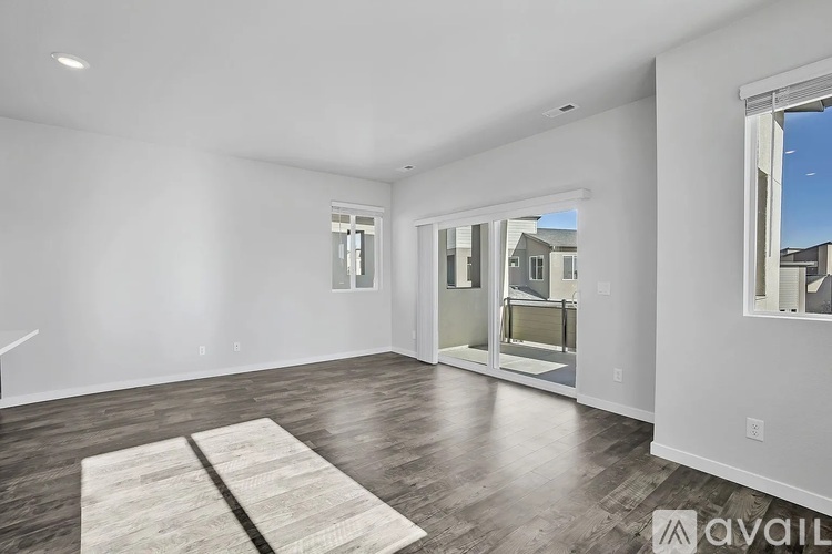 A spacious room with a rug on the floor and a sliding glass door leading outside.