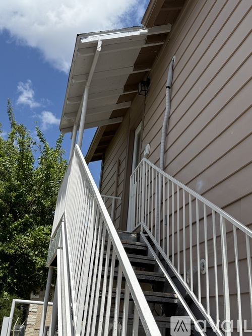 A staircase with a metal railing leads up to a building.