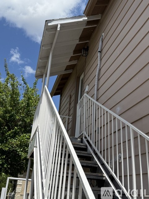 A staircase with a metal railing leads up to a building.