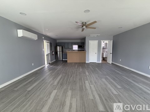 A spacious room with a ceiling fan and wooden flooring.