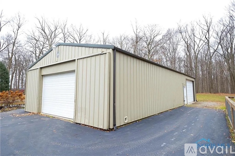 A large metal building with a closed white door and a smaller door on the side.