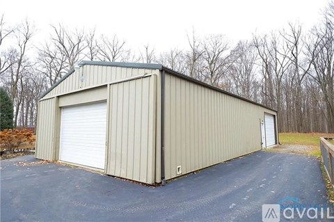 A large metal building with a closed white door and a smaller door on the side.