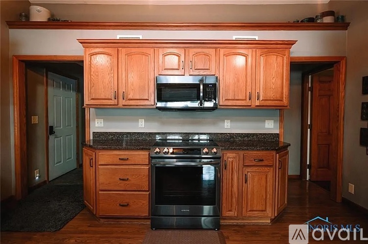 A kitchen with wooden cabinets and a black stove top oven.