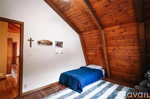 A bedroom with a bed and a cross on the wall.