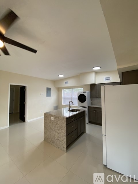A kitchen with a white refrigerator and a ceiling fan.