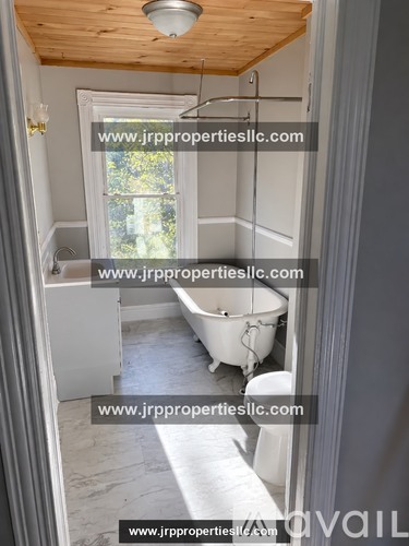 A bathroom with a tub and toilet in it.