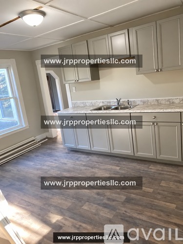 A kitchen with wooden floors and white cabinets is available for rent.