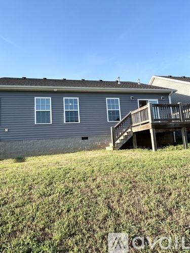 A house with a grey exterior and a deck in front.