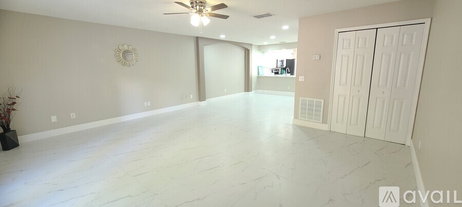 A spacious room with a ceiling fan and a mirror on the wall.