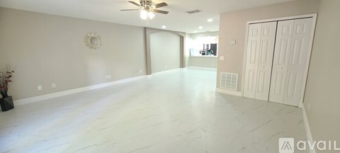 A spacious room with a ceiling fan and a mirror on the wall.