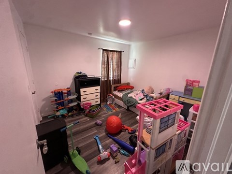 A child's bedroom with a bunk bed and toys scattered on the floor.