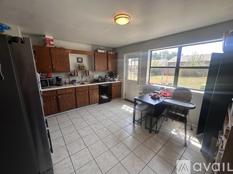 A kitchen with a refrigerator, microwave, oven, and sink.