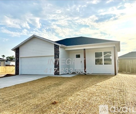 A house with a garage and a driveway in front.