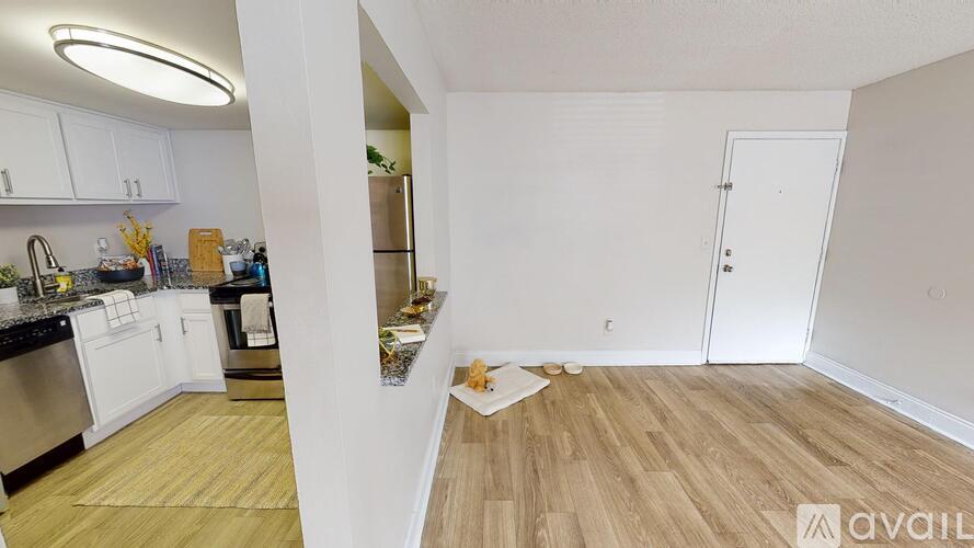 A kitchen with white cabinets and a wooden floor.