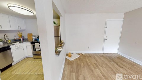 A kitchen with white cabinets and a wooden floor.