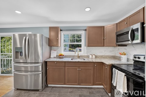 A kitchen with brown cabinets and a stainless steel refrigerator.