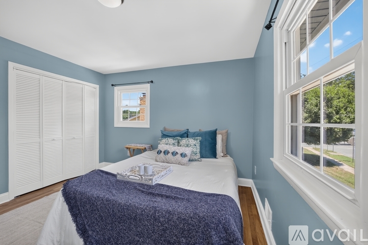 A bedroom with a bed, pillows, and a window.