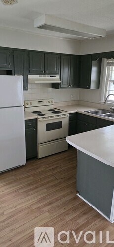 A kitchen with a white refrigerator and a white countertop.