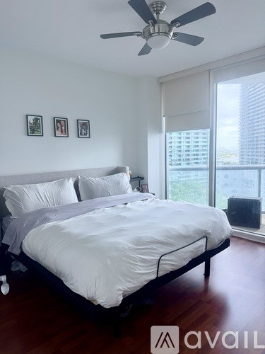 A bedroom with a large bed and a ceiling fan.