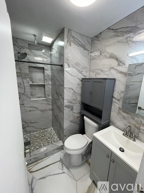 A bathroom with marble walls and a white toilet.