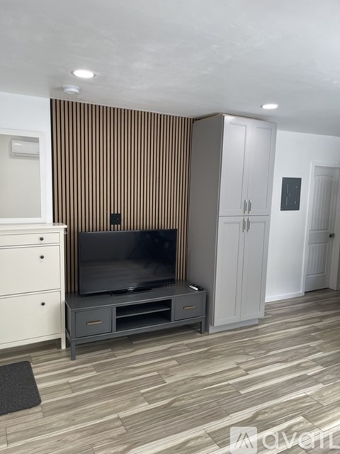 A living room with a television and a cabinet.
