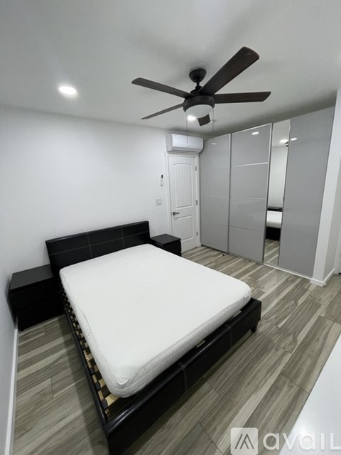 A bedroom with a bed, wardrobe and ceiling fan.