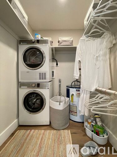 A small laundry room with a washer and dryer stacked on top of each other.