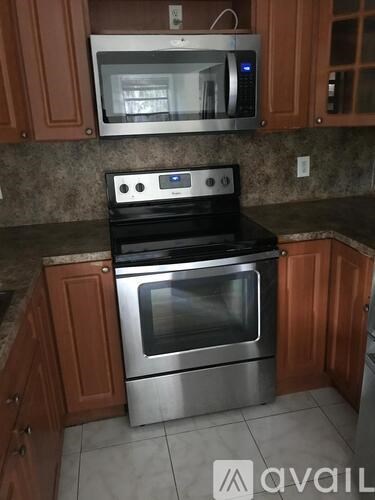 A kitchen with a stove and microwave above it.