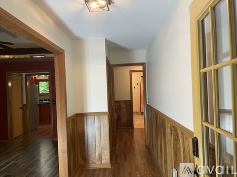 A hallway with wooden floors and white walls.