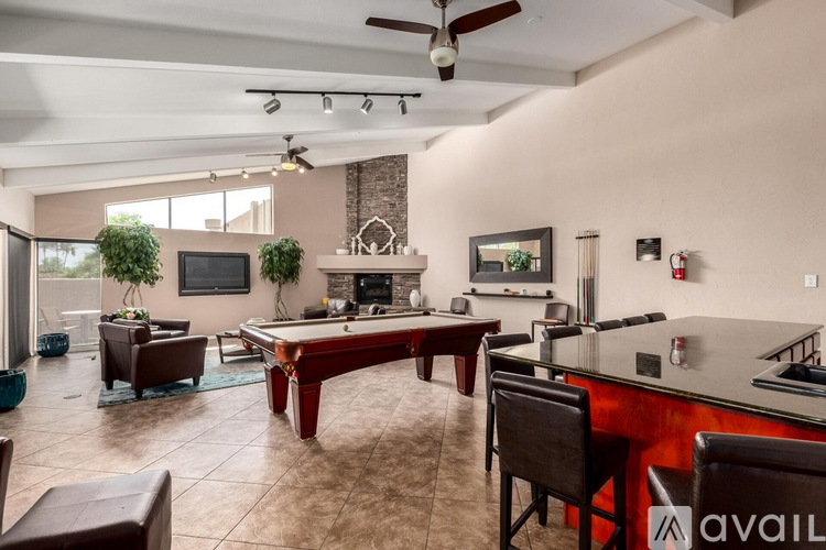 A modern living room with a pool table and a bar area.