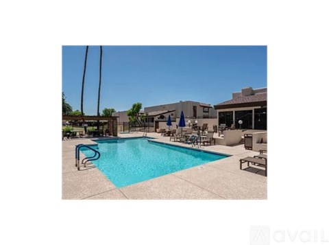 A pool with a blue water and a chair around it.