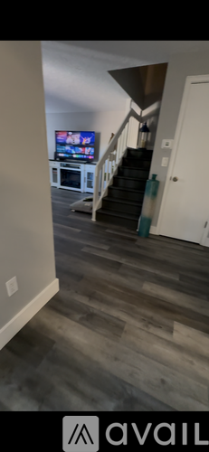 A living room with a television and a staircase.