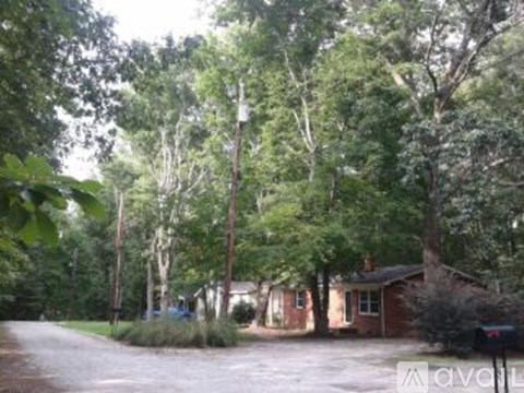 A house is surrounded by trees in the image.