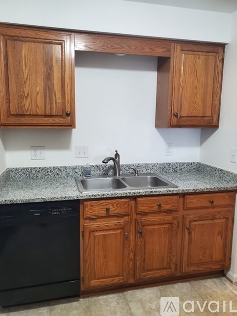 A kitchen with wooden cabinets and a granite countertop.