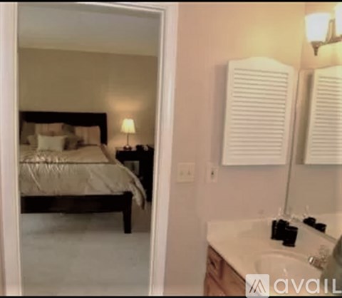 A bedroom with a bed, nightstand, and a lamp.