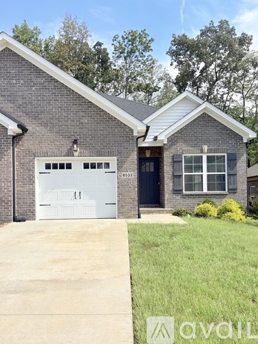 A house with a garage door and a window is for sale.